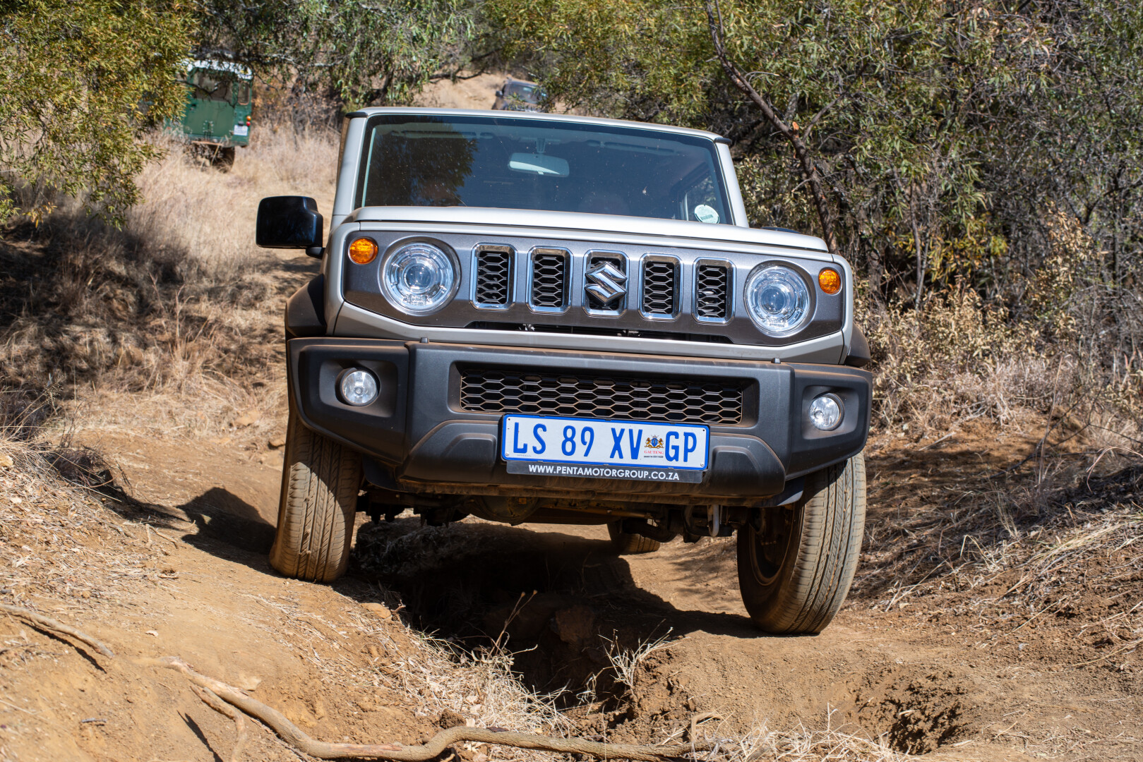 Suzuki Jimny tackling an offroad obstacle